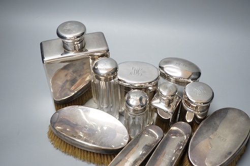 Six assorted George V silver mounted glass toilet jars, a similar brush set, a silver napkin ring and a large silver hip flask?, London, 1919, 17.3cm, 12.5oz.